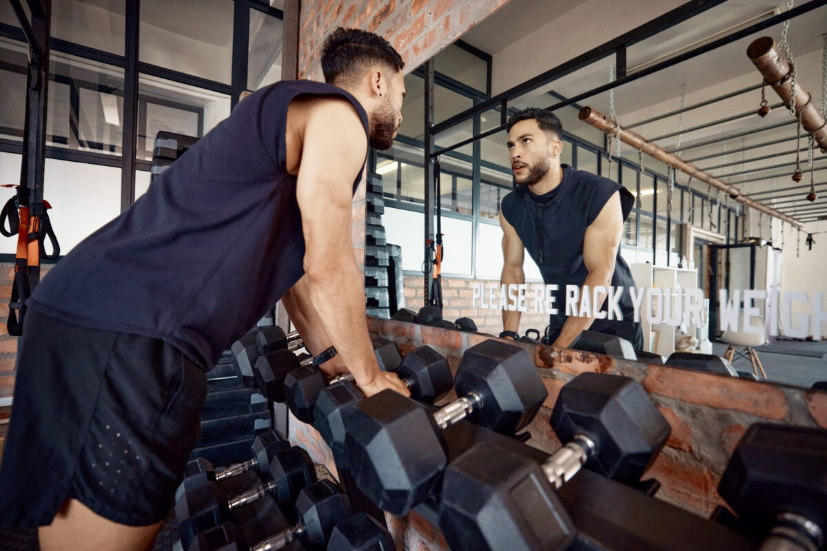 11 Common Pitfalls That Prevent People From Getting In Shape 4 If you can face yourself, you can face anything. a sporty young man looking at himself in a mirror while exercising in a gym.