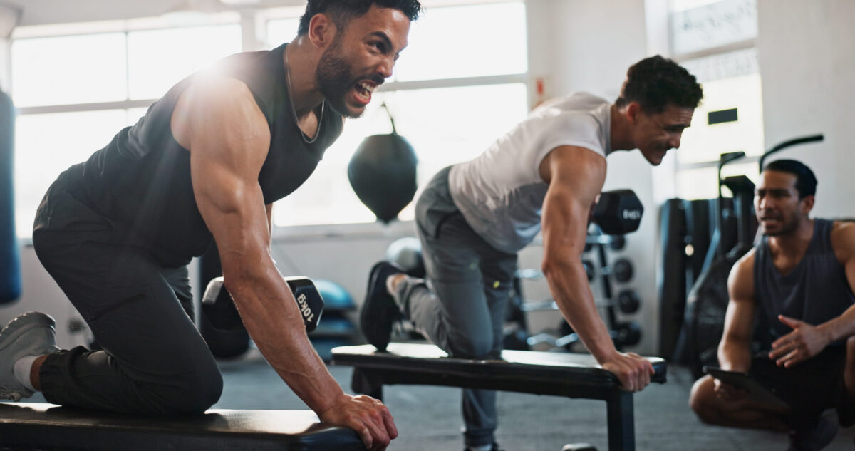 Fitness, personal trainer and men in gym with weights for bodybuilding training, exercise and workout. Sports, serious and people with weightlifting equipment for muscle strength, health or challenge