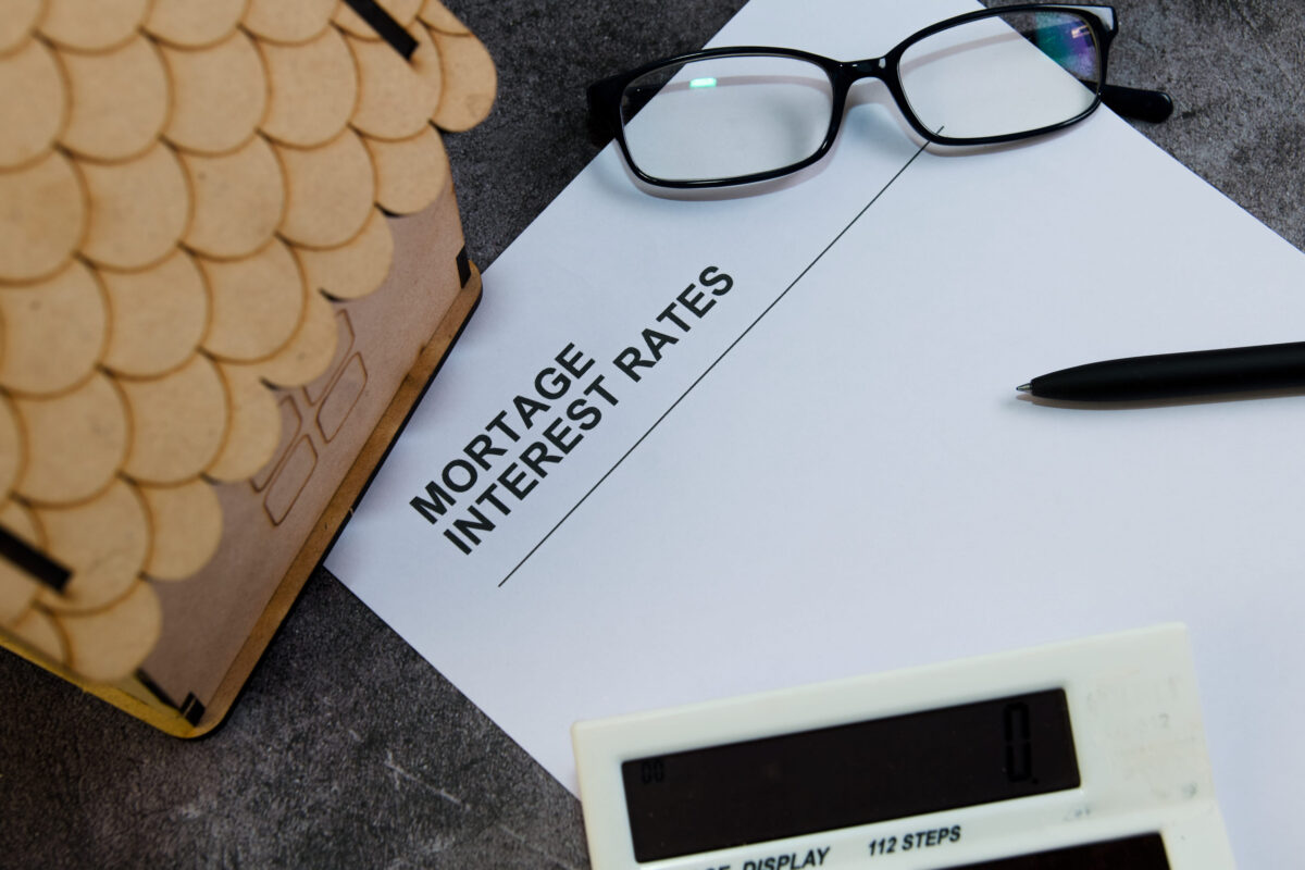 A detailed study of mortgage interest rates with glasses, a pen, and a calculator on a desk.