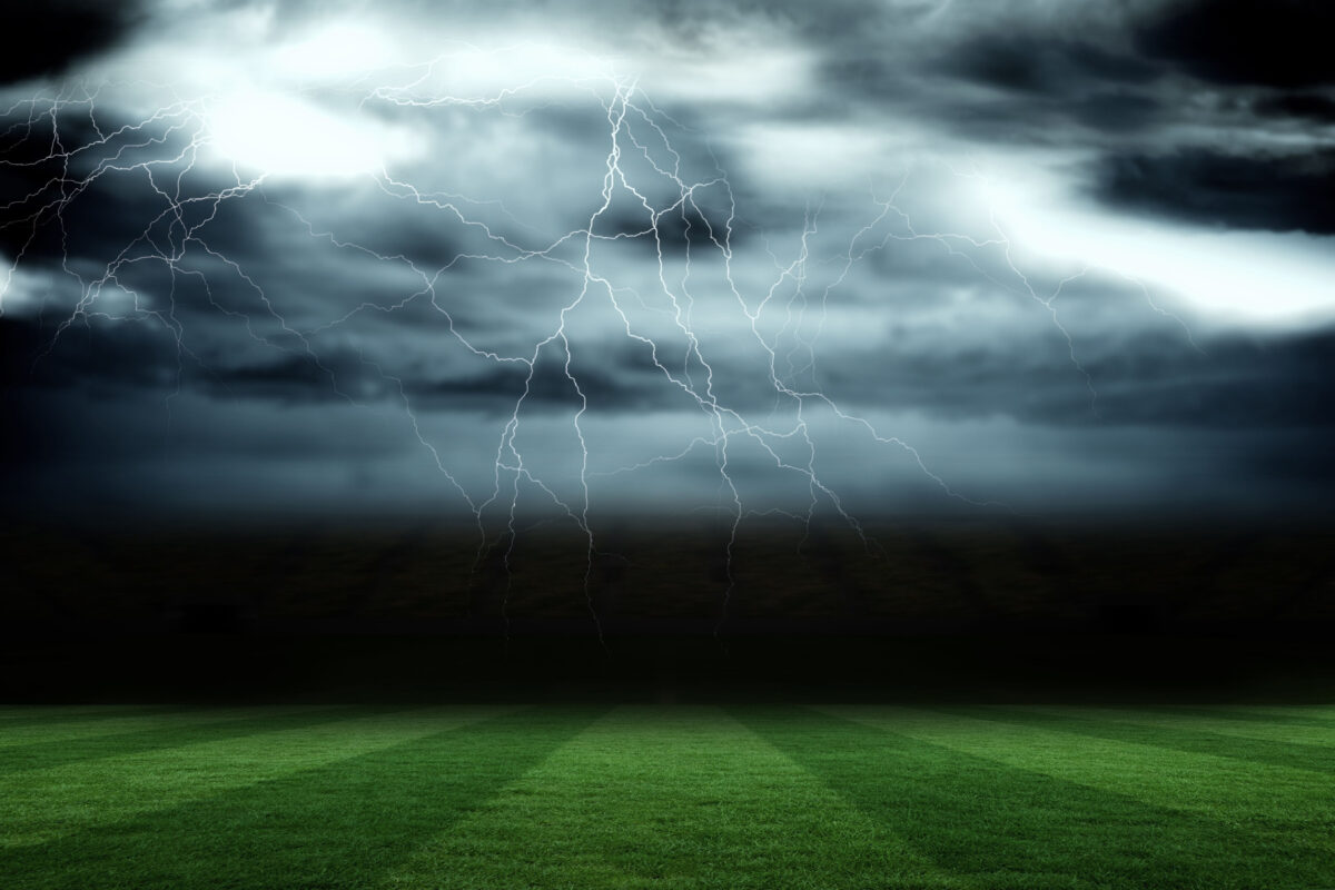 Digitally generated football pitch under stormy sky