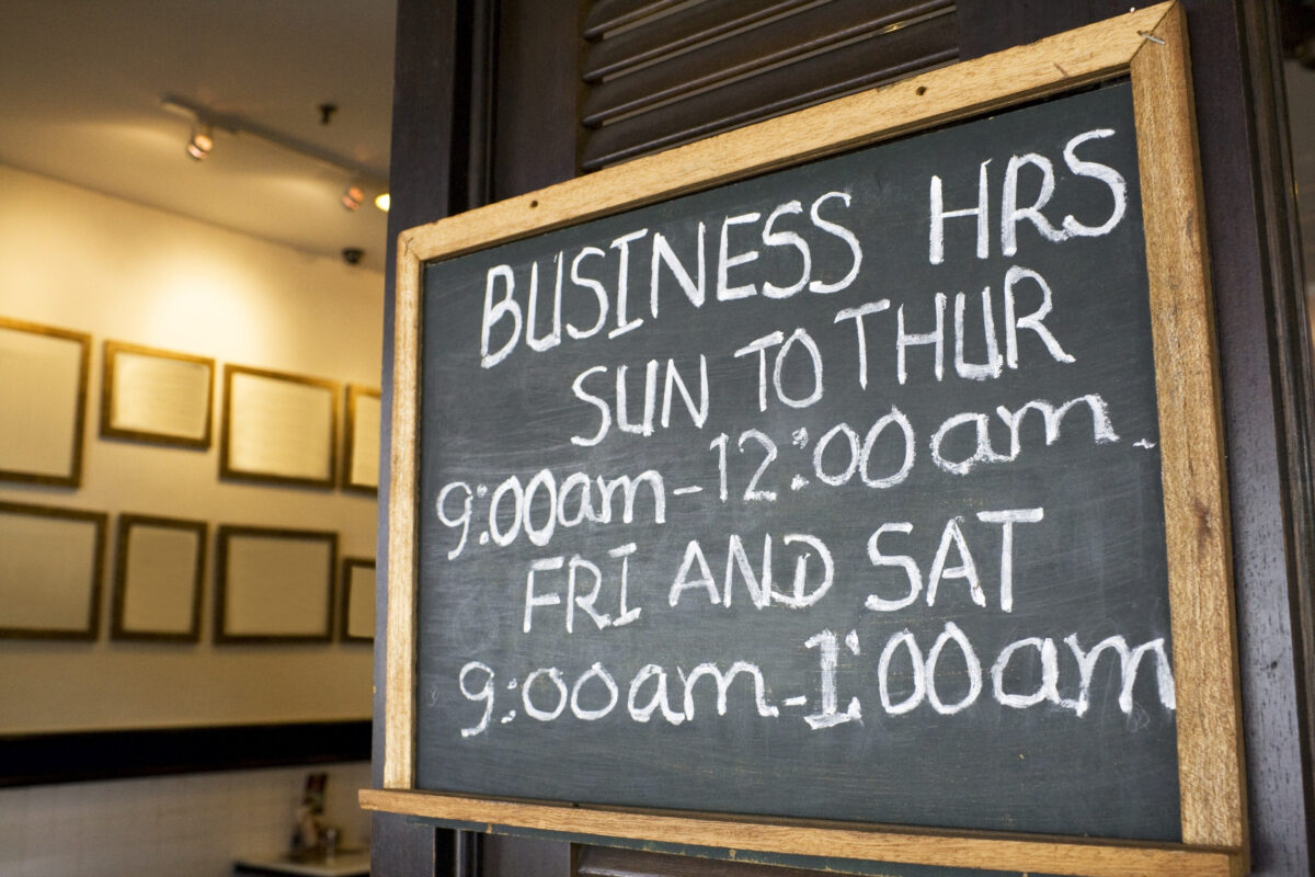 Business opening hours signboard on display.