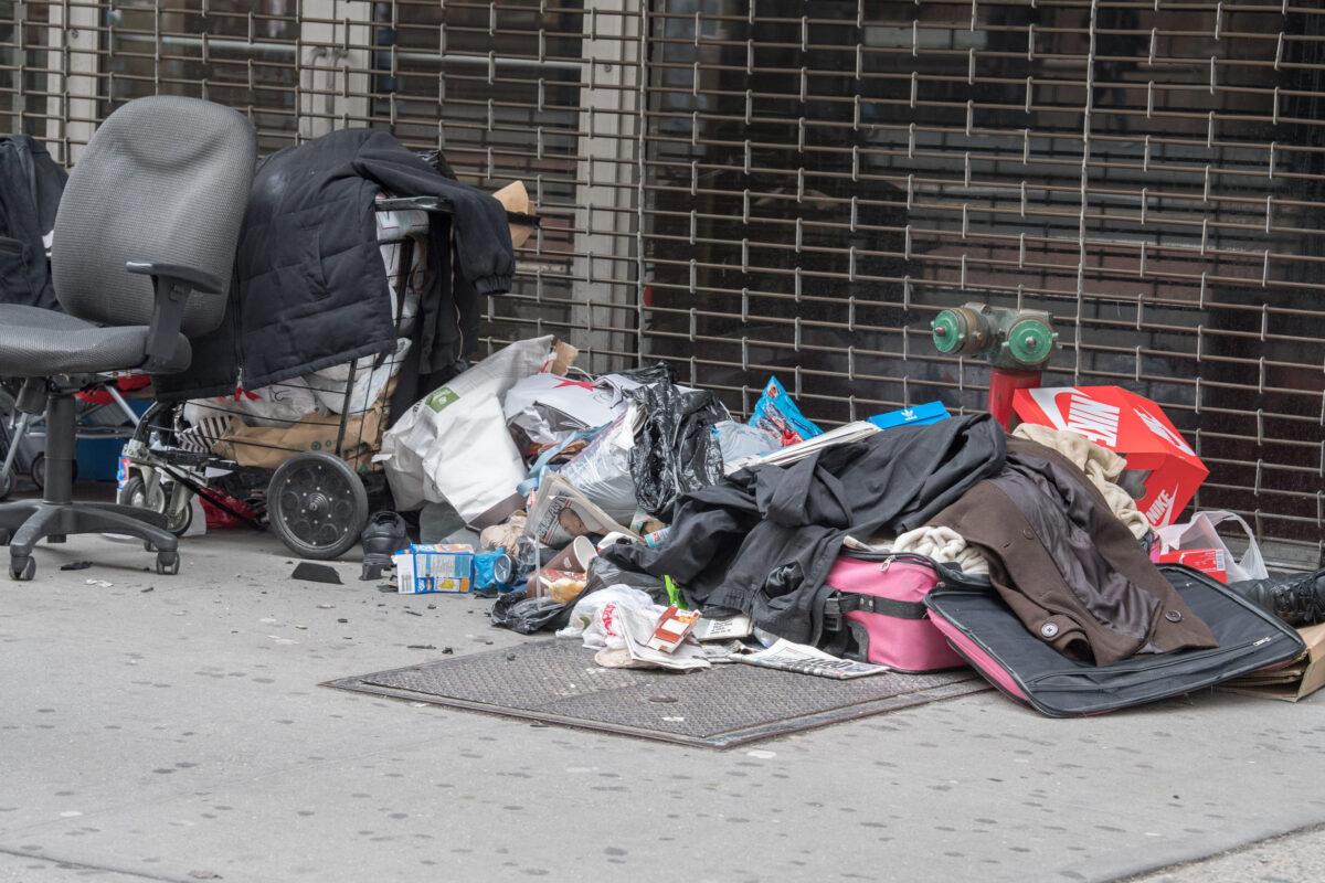 NEW YORK, USA - APRIL 21 2017 - poor homeless in city street with his belongins