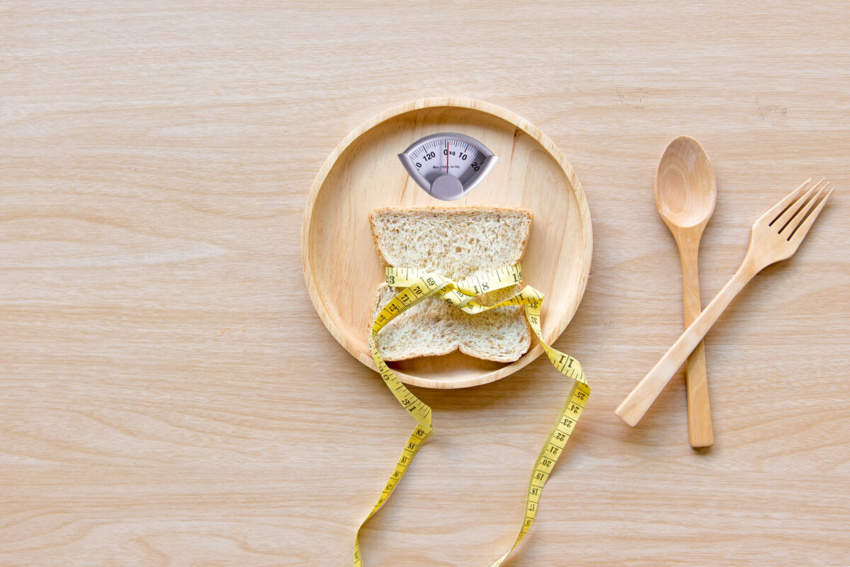 11 Reasons Why Viral Recipes Fail And How We Waste Ingredients 2 Weight scale with wholesome slice of bread and measuring tape on the wood plate for slimming weight. Diet and Healthy Concept