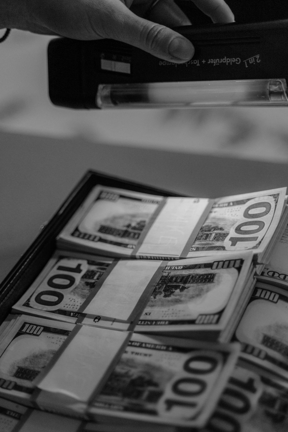 10 Things Americans Should Know When a Country Runs Out of Money 2 A black and white close-up of hundred dollar bills examined under UV light.