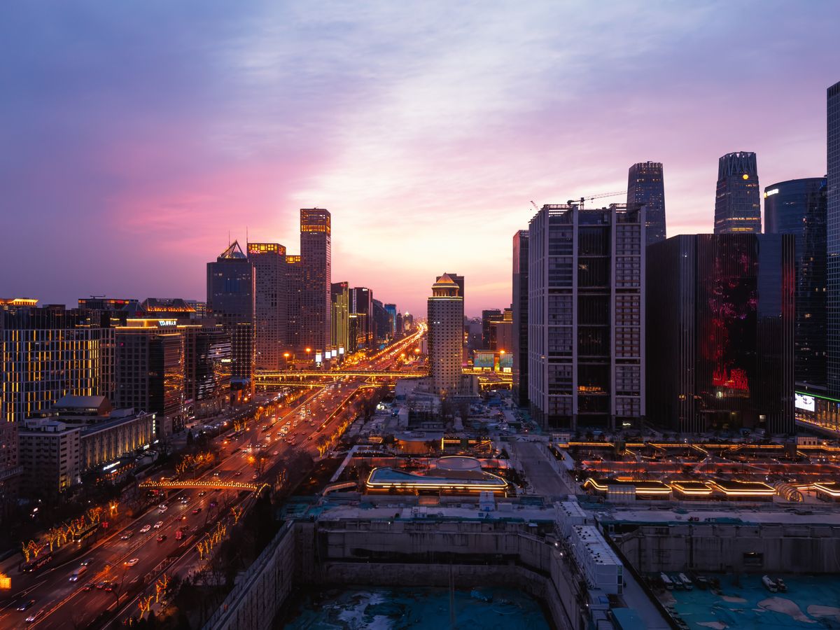 10 Major Cities Literally Being Swallowed by the Earth: A Terrifying Global Collapse 2 A breathtaking panoramic view of Beijing's urban skyline at dusk with vibrant city lights and a colorful sky.