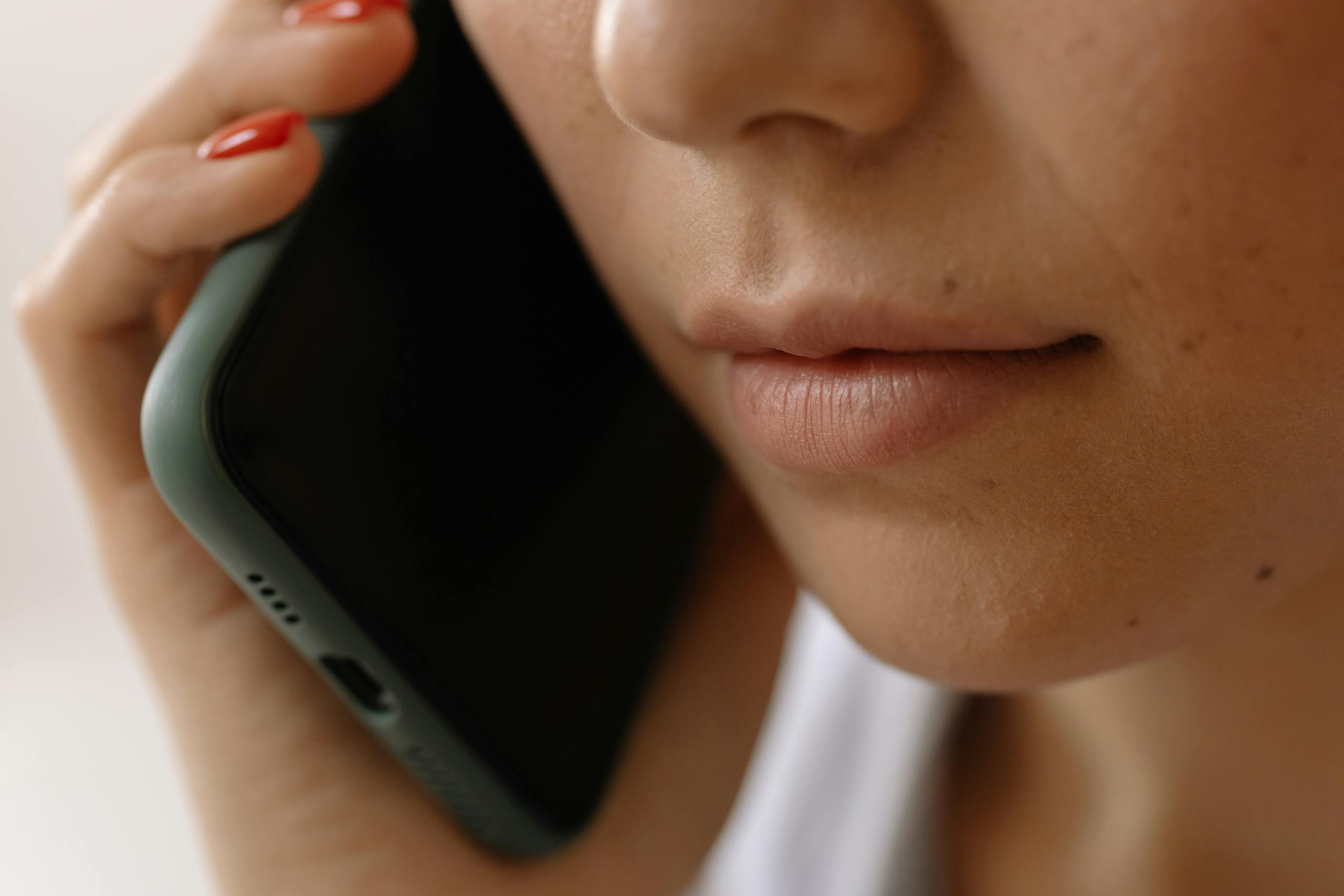 8 Gross Things People Put Near Their Mouth Without Thinking 1 A close-up image of a woman holding a smartphone to her ear, emphasizing communication.