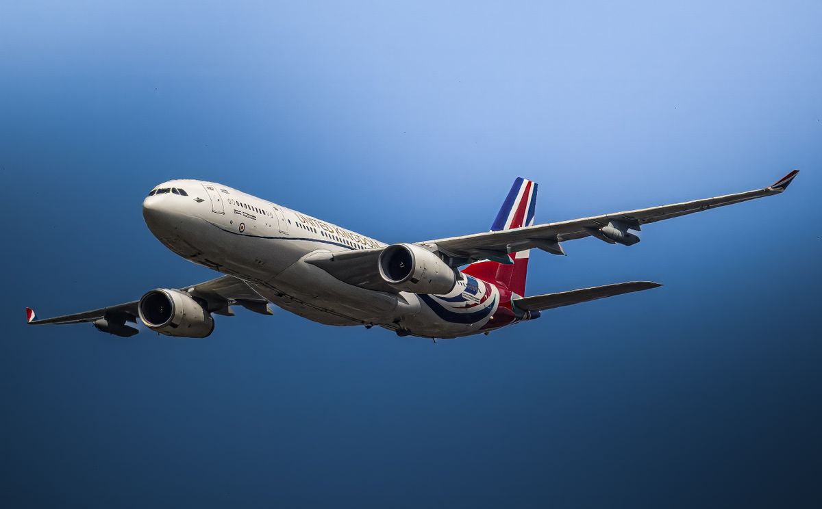 The Climate Habit Nobody Wants to Talk About: How Rich and Middle-Class Lifestyles Are Heating the Planet 2 A close-up view of a commercial airplane flying against a clear blue sky.