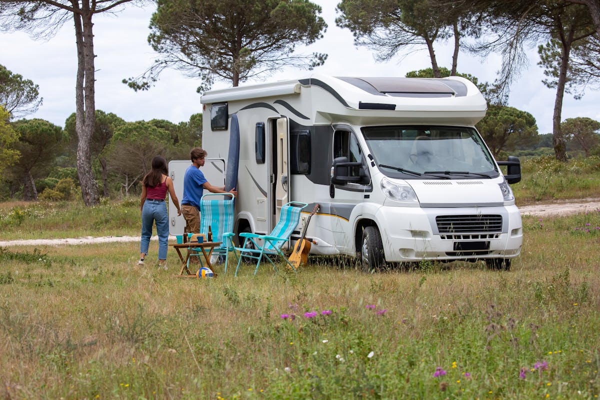 Florida RV Crackdown Leaves Poor and Elderly Residents Facing a Shrinking Housing Escape Route 1 A couple enjoys a camping trip with their RV in a scenic grassland, surrounded by nature.