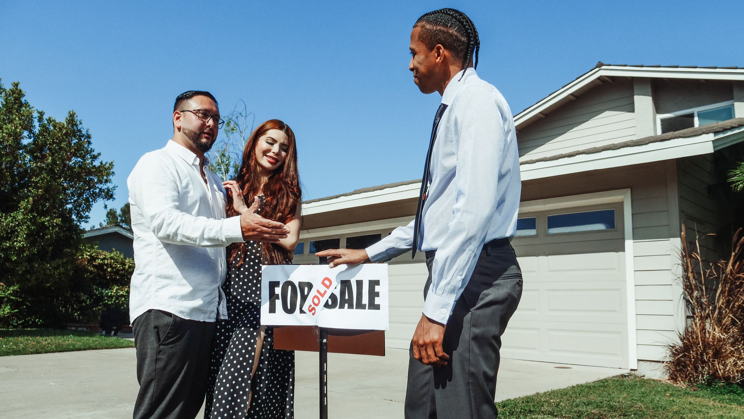 Texas Homebuyers Face New Sticker Shock as Government Regulations Add Nearly $132,000 to New Homes 1 A couple meets with a realtor to finalize the purchase of their new home, indicated by a 'Sold' sign.