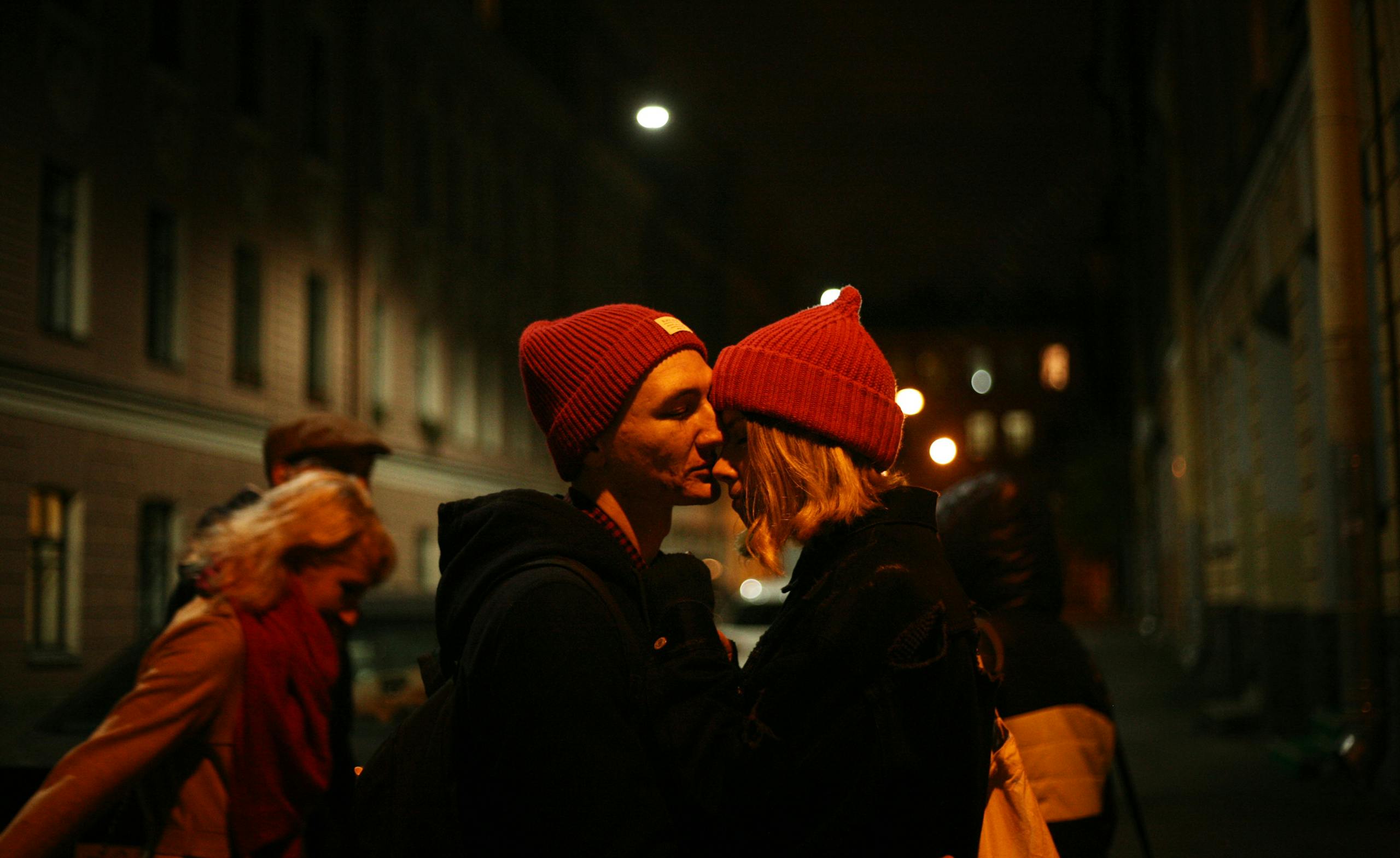 Young Man Tells Girlfriend He’d Rather Take Care of Himself After Two Sexless Years 1 A couple shares a romantic kiss on a dimly lit street at night, embodying love and togetherness.