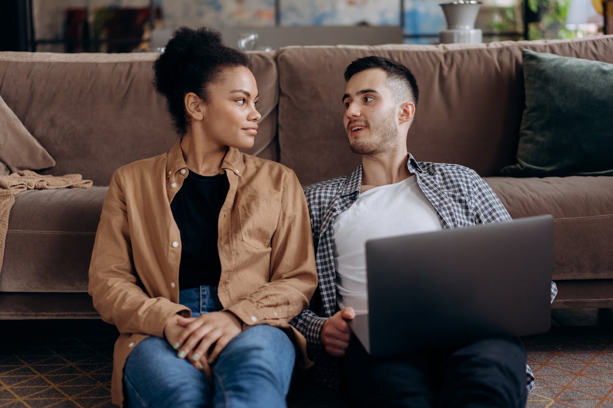 10 Warning Signs Your Marriage Is Slowly Destroying You 3 A couple sitting on the floor at home, using a laptop and sharing a moment.
