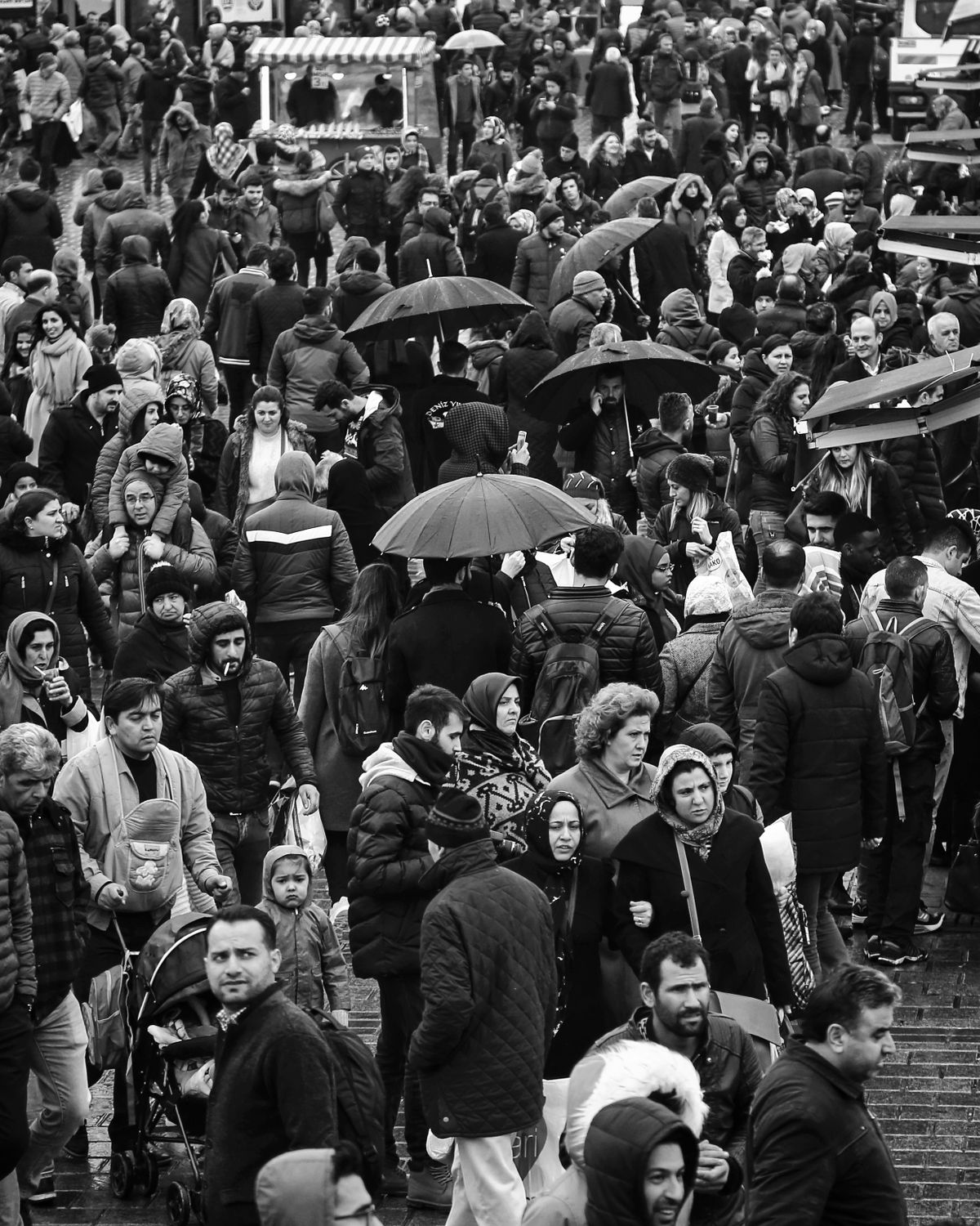 A crowded Istanbul street full of pedestrians, showcasing urban life in black and white.