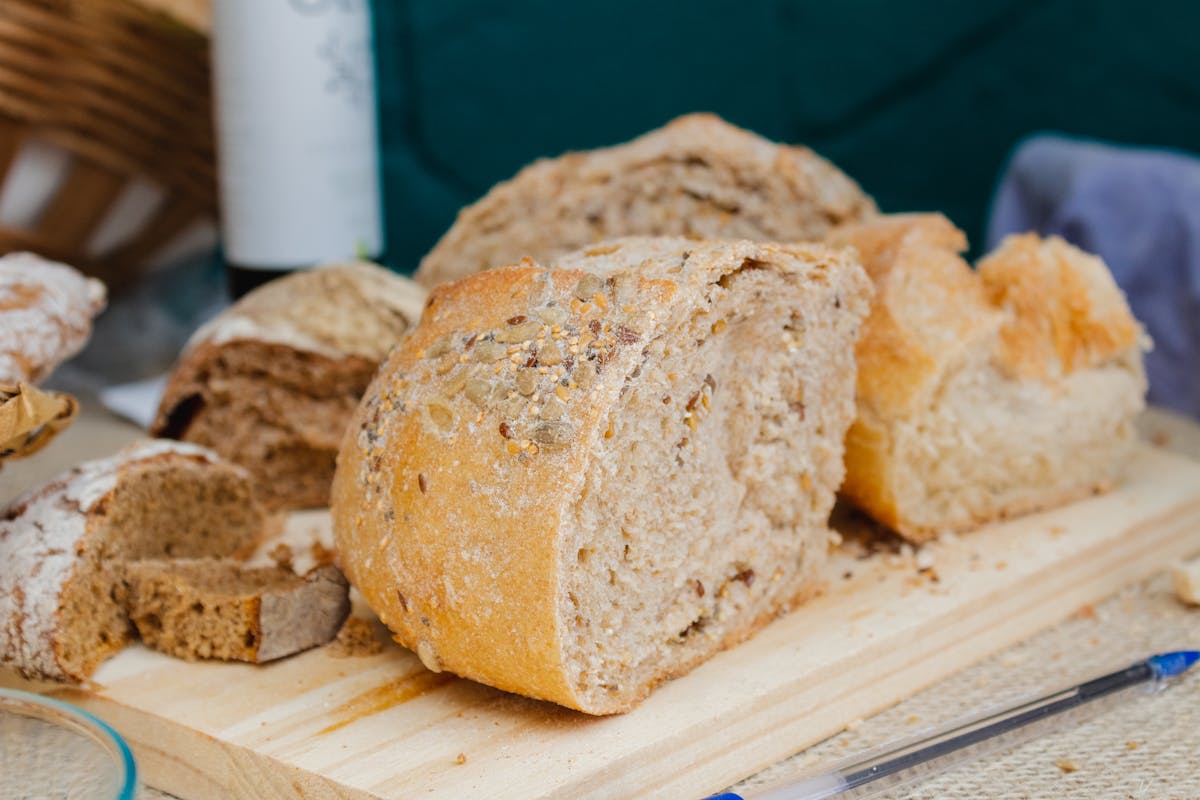 A delicious assortment of freshly baked artisan breads displayed on a wooden board, perfect for a rustic meal.