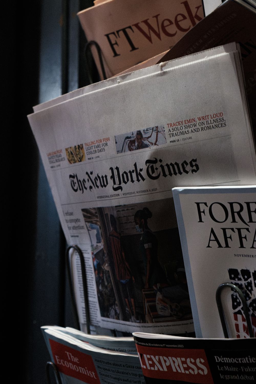 A detailed look at a newspaper stand showcasing The New York Times and other publications.