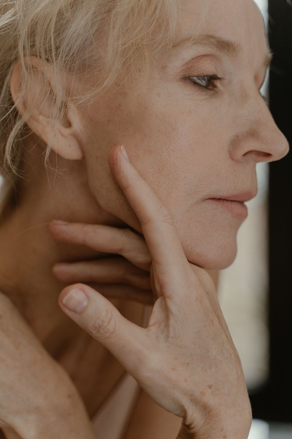 A graceful senior woman in a side profile portrait, exuding elegance and wisdom.