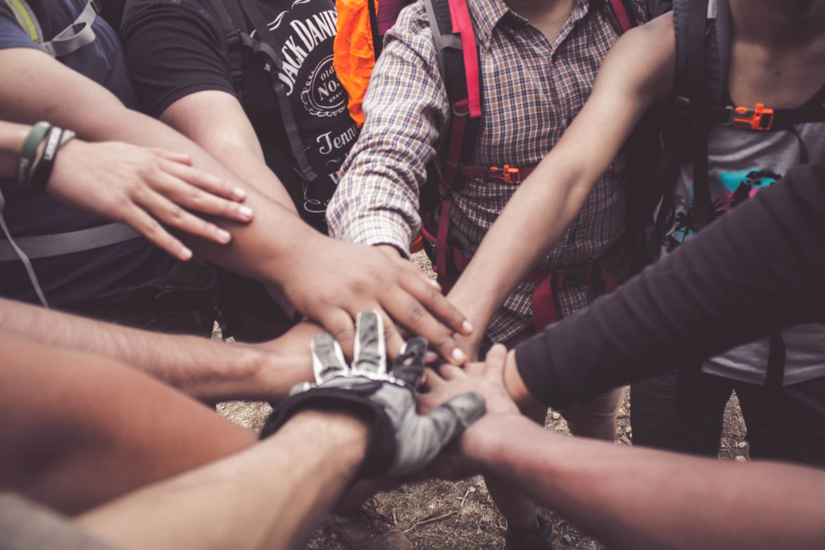 10 Things Retirees Miss About Working That Make Retirement Feel Strangely Empty 3 A group of diverse individuals join hands for teamwork in West Java, Indonesia.