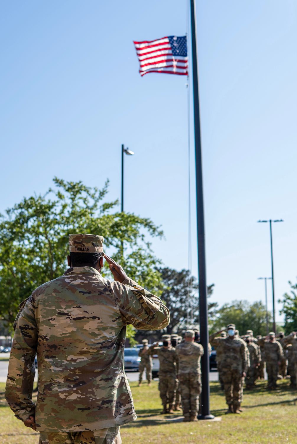 The Military Salute You’ve Been Misreading Your Whole Life 1 A group of soldiers in uniform salute the American flag during a daytime ceremony.