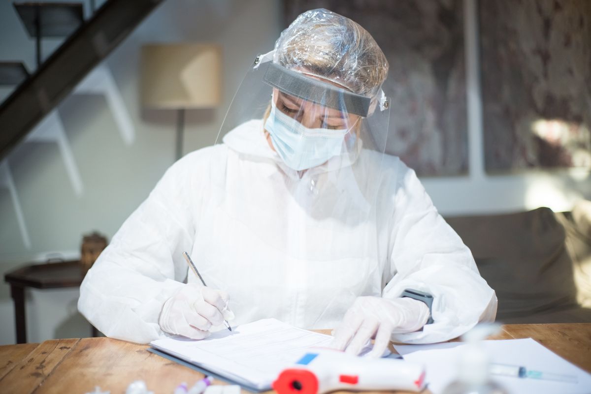 Reality TV Star :Francine Beppu’s Cause Of Death Revealed 1 A healthcare professional in full protective gear is focused on writing at a desk inside a modern setting.