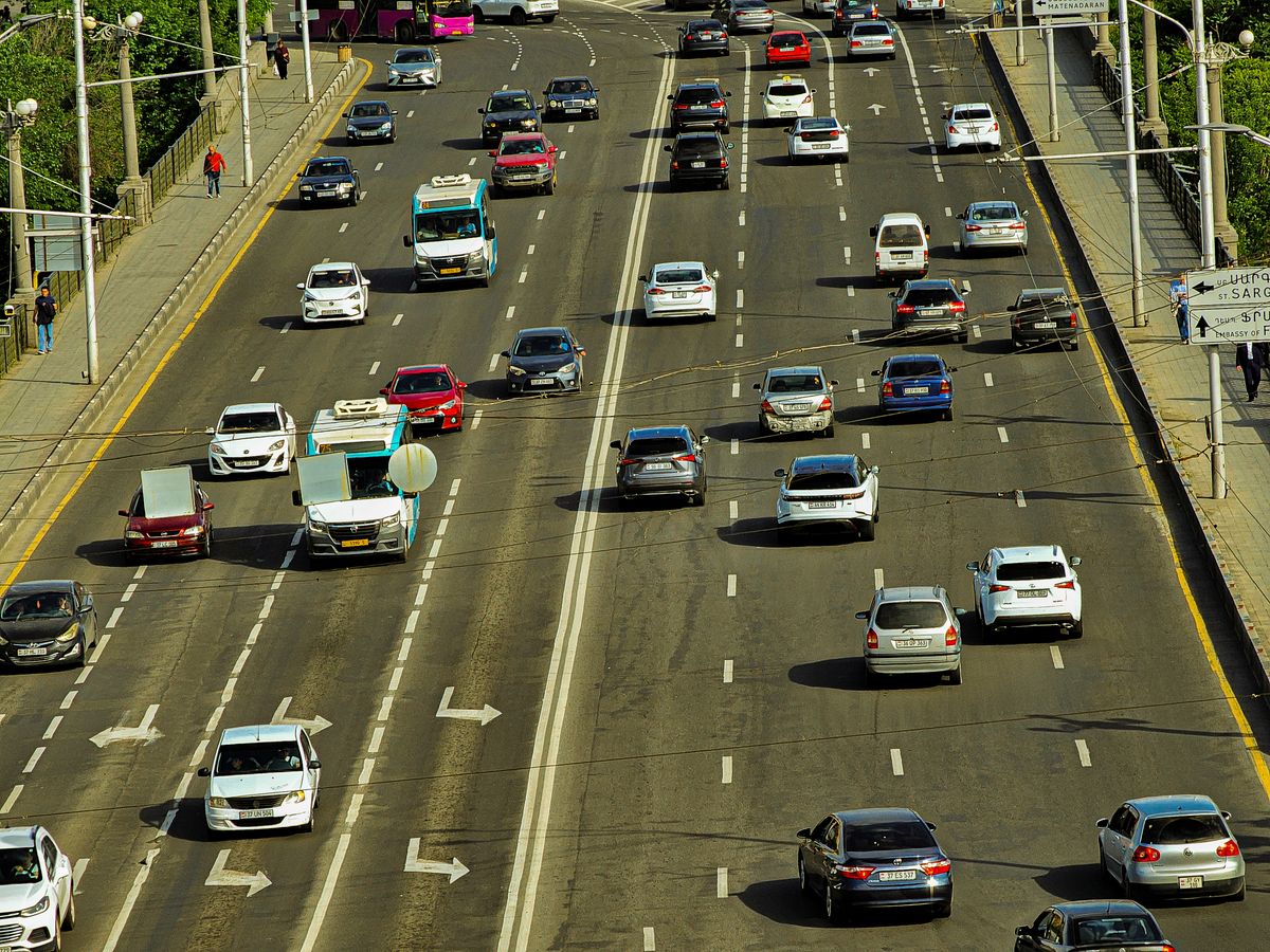 A high-angle view of a busy urban highway with several cars, showcasing city transportation.