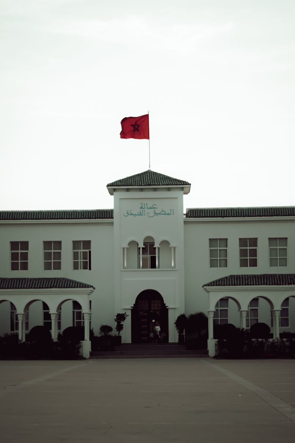 A Moroccan governmental building adorned with the national flag highlighting its architectural style.
