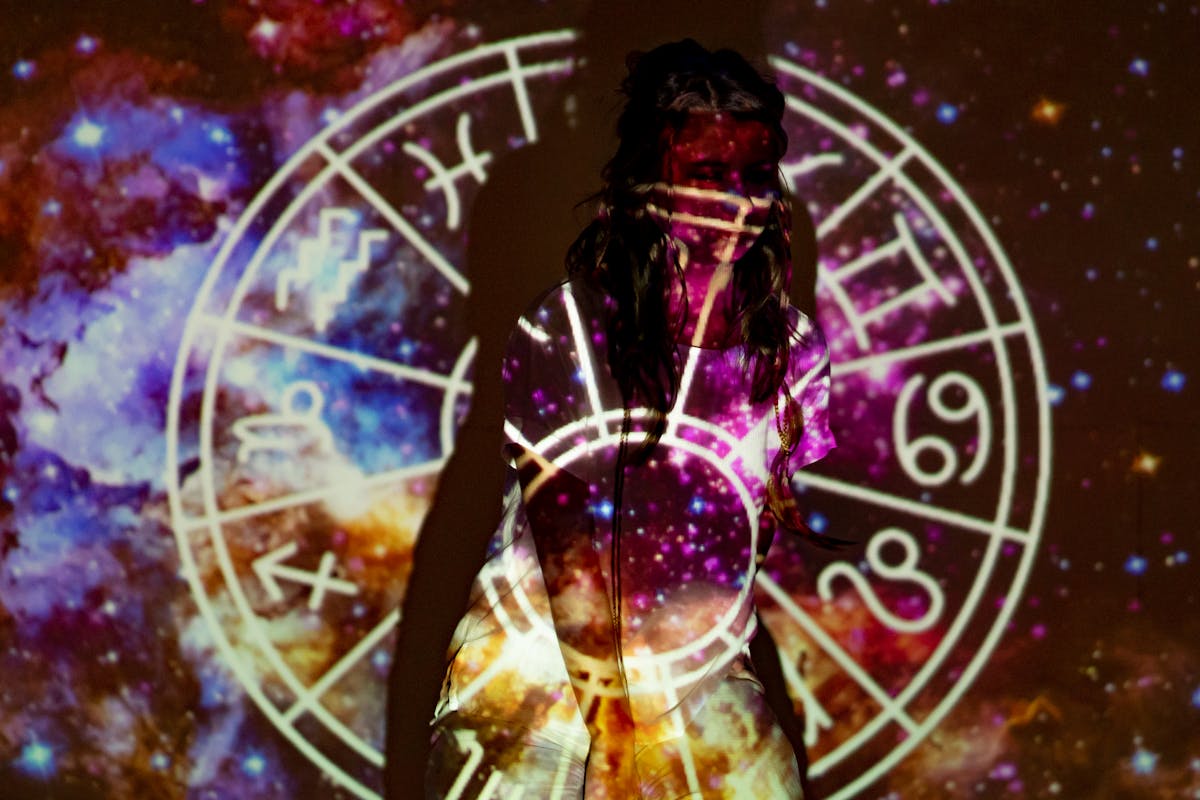 The Zodiac Signs Most Likely to Outlast Humanity’s Collapse 2 A mystical image of a woman enveloped in celestial projections and astrological symbols.