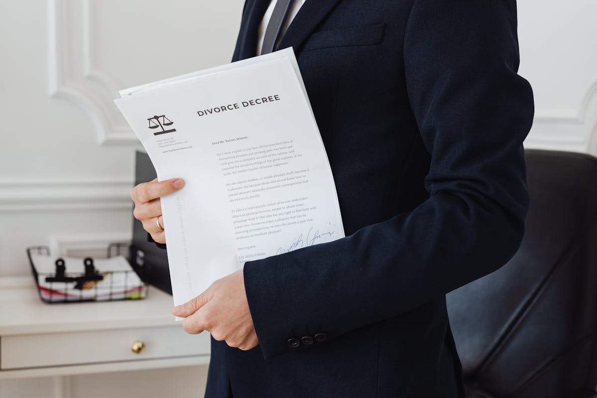 10 Social Security Mistakes Women in Their 50s Should Fix Before Retirement Gets Expensive 3 A person holding a divorce decree in an office setting, symbolizing legal proceedings.
