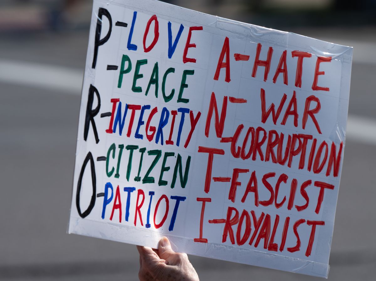 A placard sign emphasizing pro-love, peace, and integrity, against hate and war.