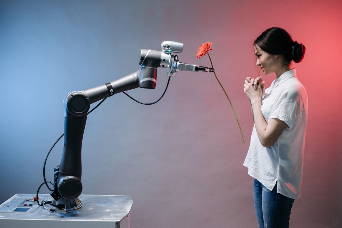 10 Job Skills You’re Ignoring That Are Killing Your Career 1 A robotic arm offers a flower to a woman in a display of technology and human connection.