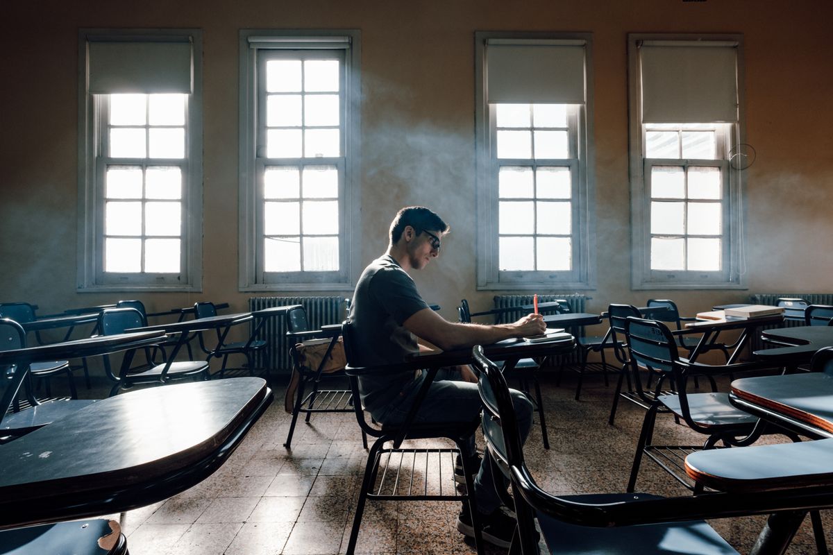 A student studies alone in a sunlit classroom at a Buenos Aires university.