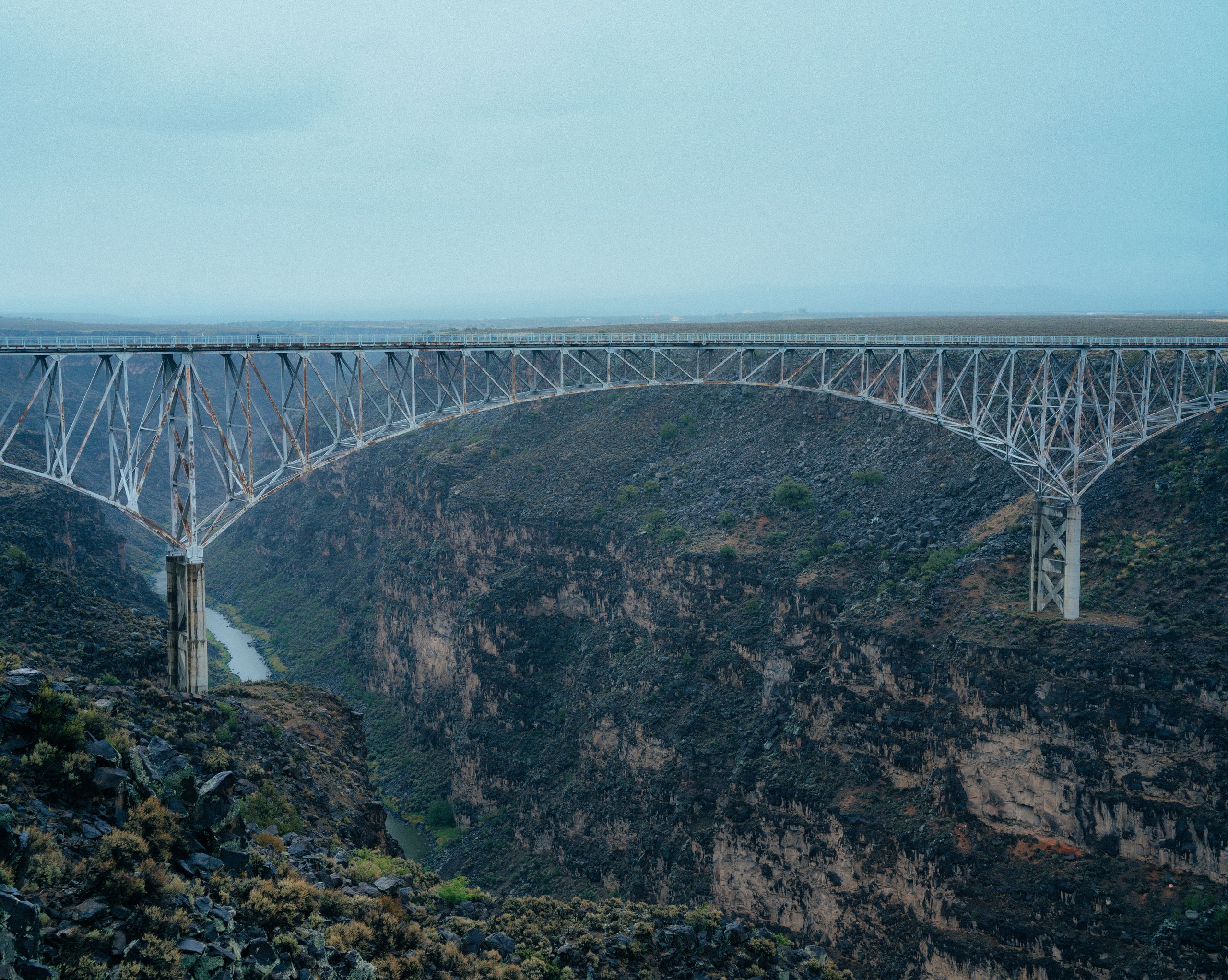 Bridges in the USA Aren’t as Safe or Simple as They Seem 4 A stunning view of a bridge arching over a deep canyon, showcasing natural beauty and engineering.