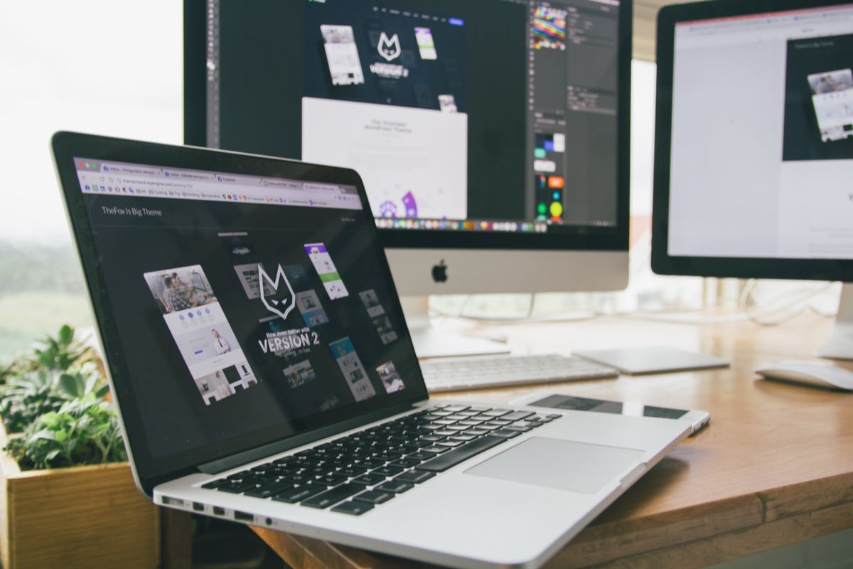 10 Small Business Website Examples That Show What High-Performing Websites Do Right 1 A stylish workspace featuring a laptop and monitors displaying design software.