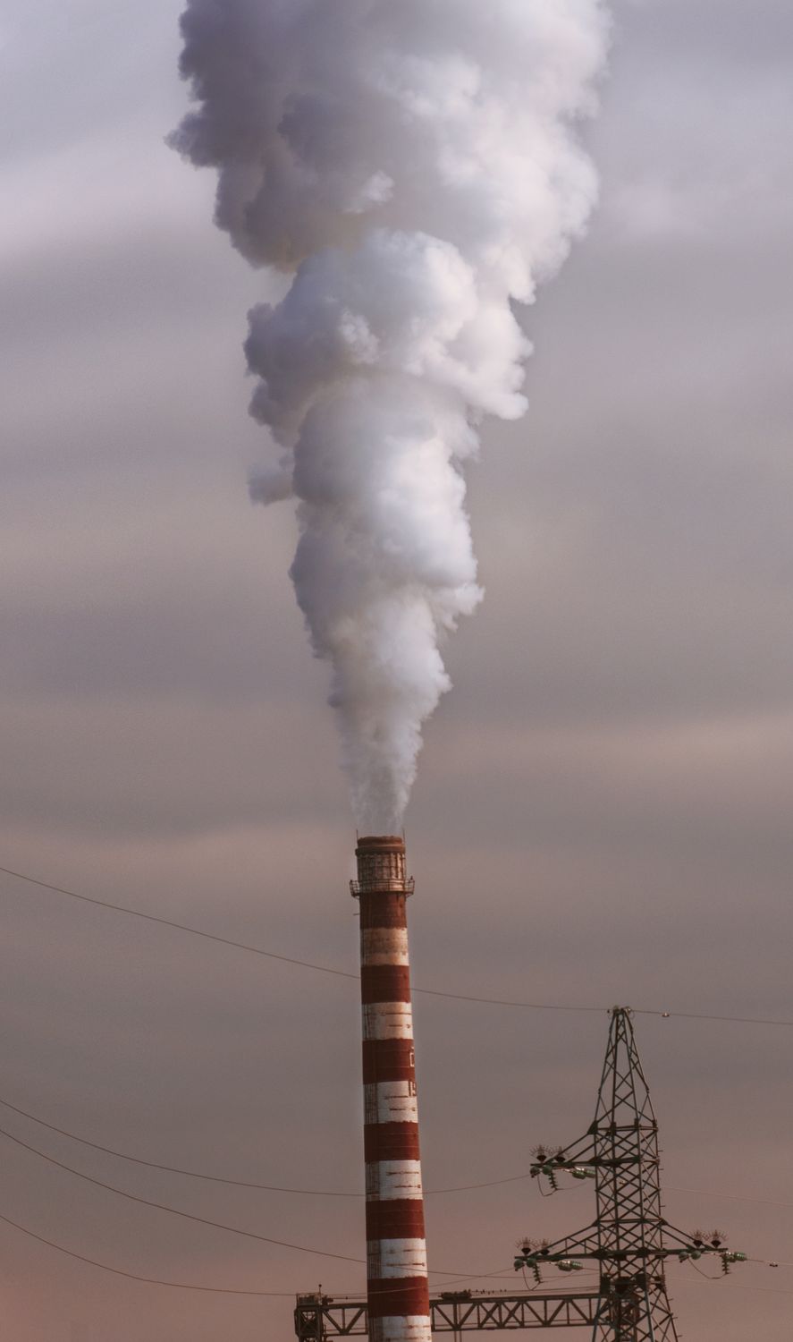 The Climate Habit Nobody Wants to Talk About: How Rich and Middle-Class Lifestyles Are Heating the Planet 1 A tall smokestack releasing dense smoke, highlighting industrial air pollution and environmental concerns.