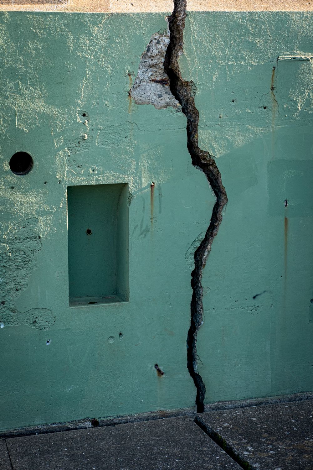 The Next Quake in California Could Be Catastrophic… Here’s Why 4 A vertical shot of a cracked green wall displaying decay and structural issues.