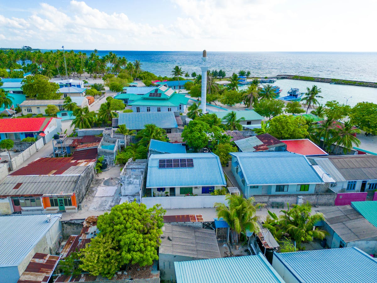 A vibrant aerial shot of Maabaidhoo village in the Maldives showcasing colorful rooftops and lush greenery.