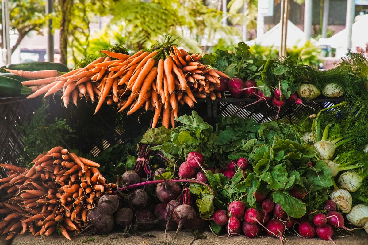 6 Popular Foods With Hidden Lead Risks 2 A vibrant display of fresh carrots, radishes, and greens at a local outdoor market.