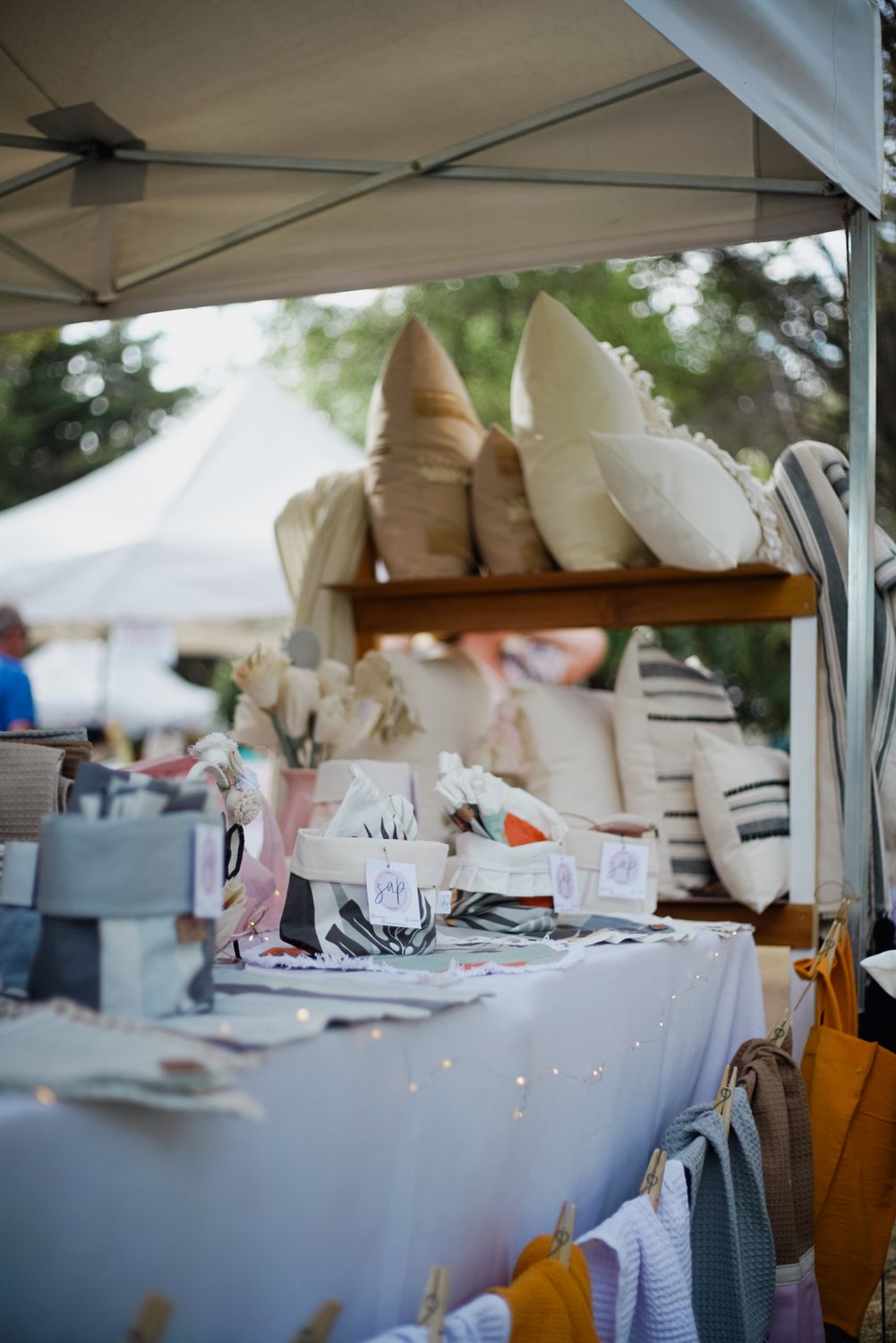 Going Global Can Grow a Business Fast. It Can Also Expose Every Weak Spot. 1 A vibrant display of pillows and linens in an outdoor market setting, showcasing texture and color.