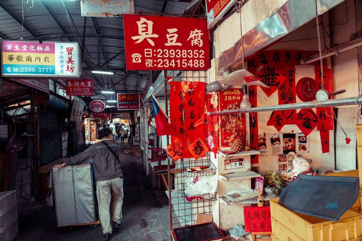 Six shocking fraud cases from 2024 show how fast money, trust, and technology can be turned against ordinary people. 1 A vibrant street market scene featuring a vendor organizing items under colorful signs.