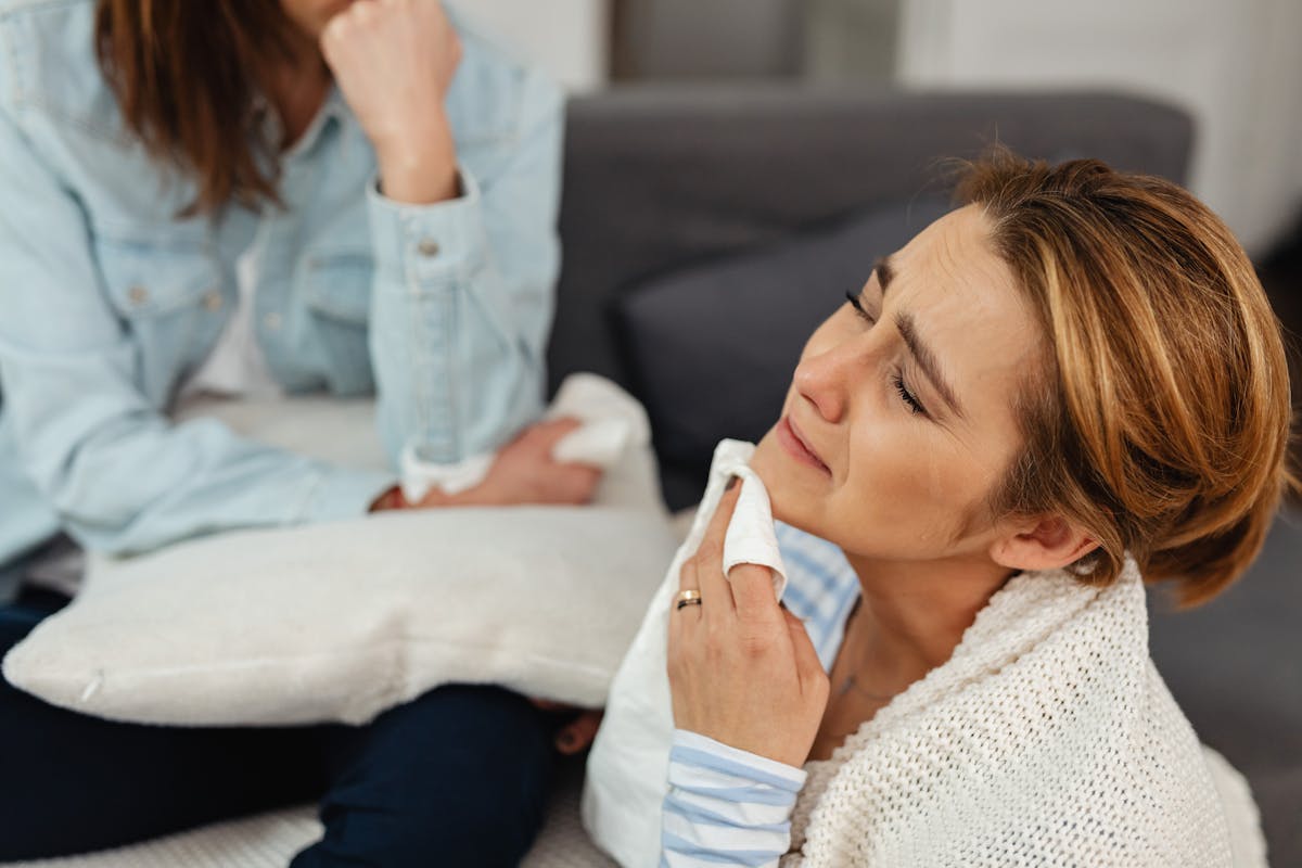 6 Terrifying Realities That Unfold When We Die 3 A woman crying with a napkin, comforted by a friend, expressing emotions.