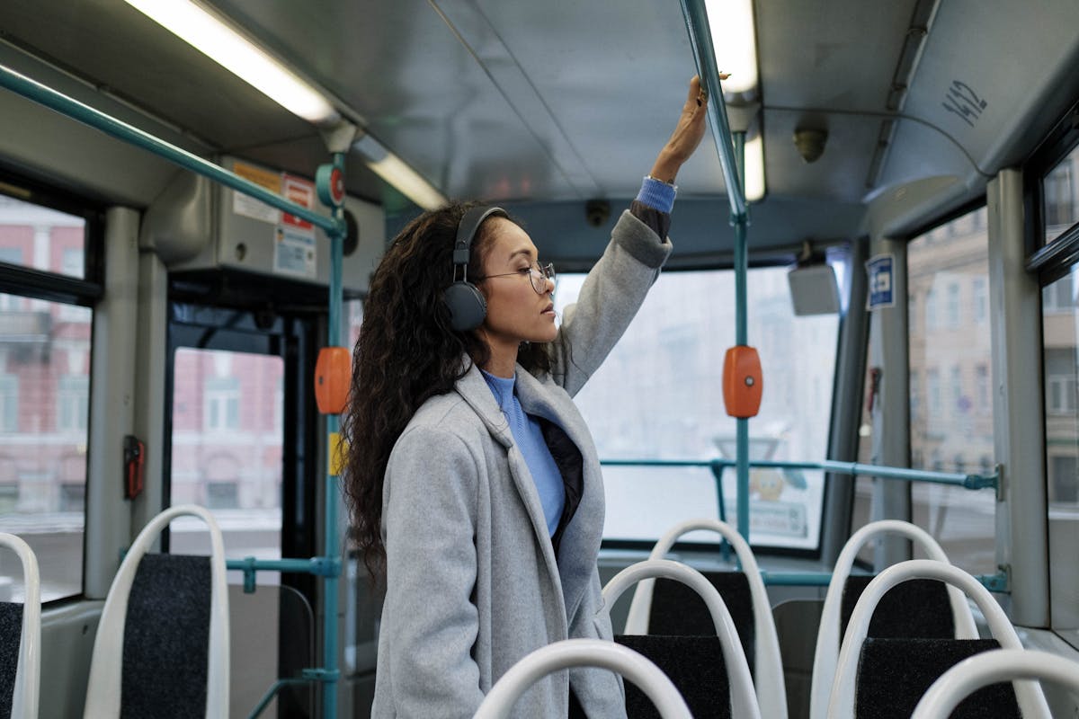 11 Everyday Things That Drive New Yorkers Absolutely Crazy 2 A woman with headphones stands inside a bus, enjoying music.