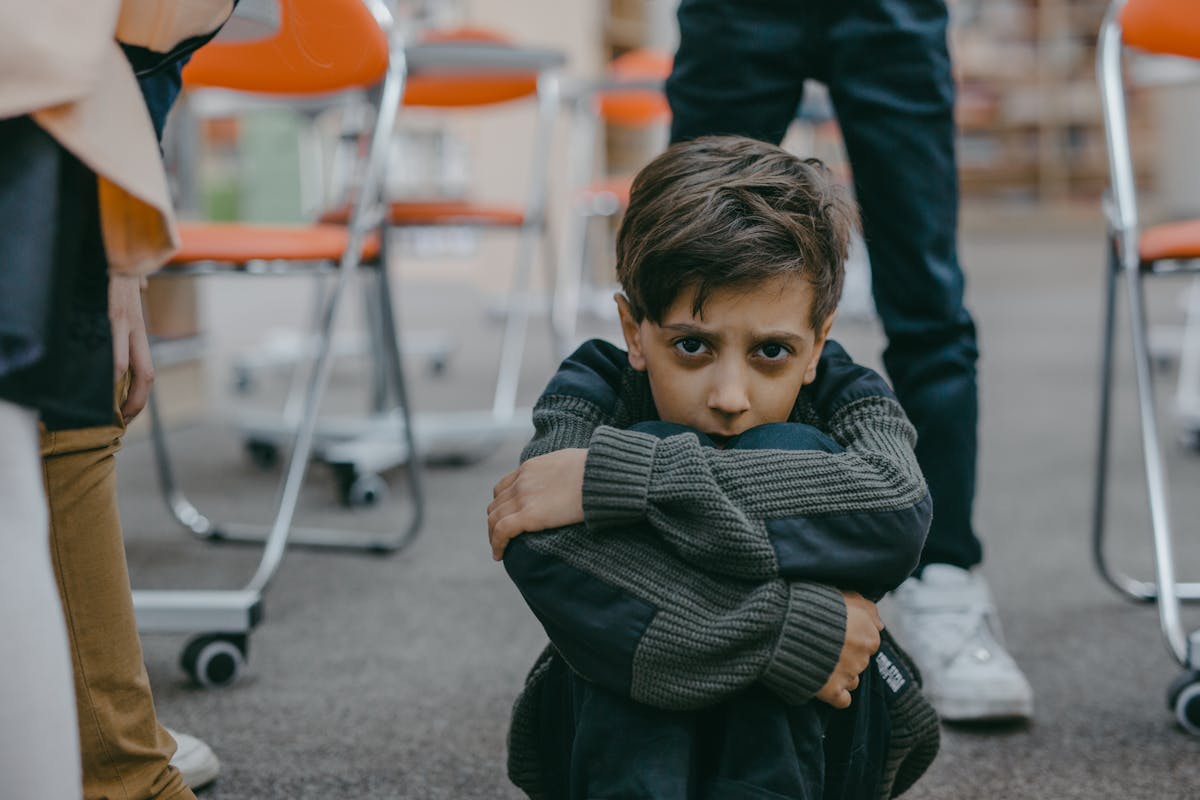 Google’s Mosquito Release Sparks Alarm: 32 Million Insects Could Backfire in California and Florida 3 A young boy sits on the floor of a classroom, expressing fear and vulnerability.