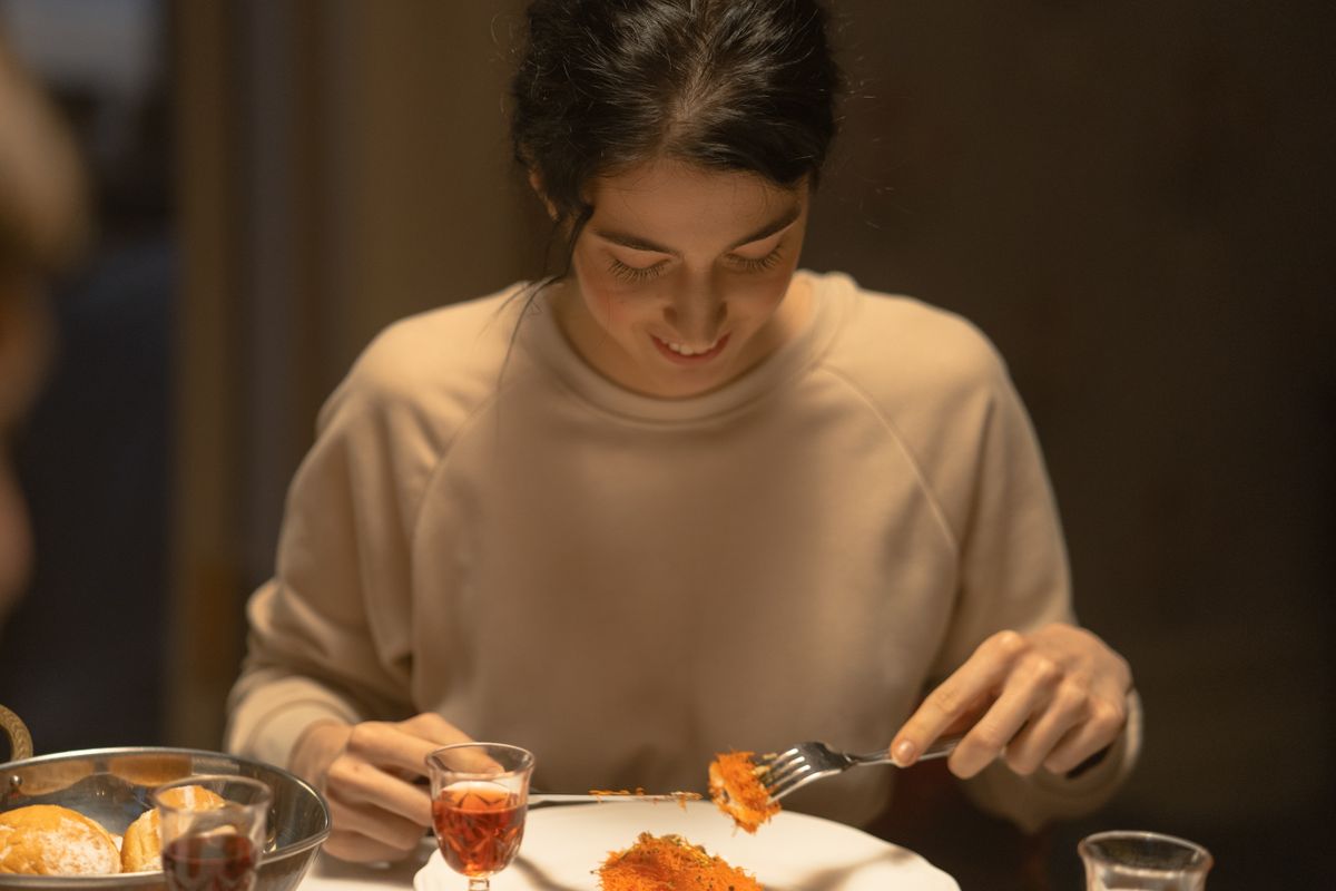 8 Weight Loss Killers Hiding In Your Daily Diet 3 A young woman enjoys a festive meal indoors with traditional food and drink.