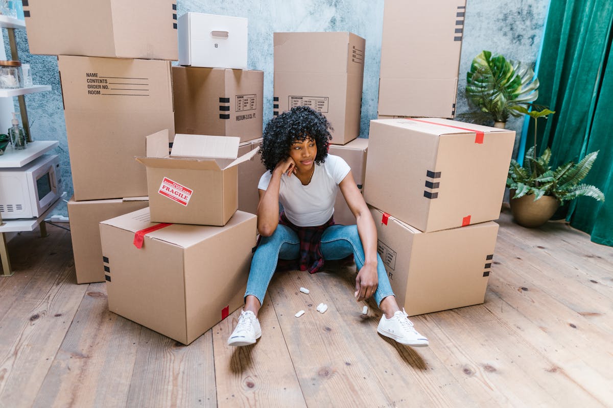 11 Reasons Florida Has Become America’s Most Punishing State for Renters 1 A young woman sitting among cardboard boxes, indicating moving day.