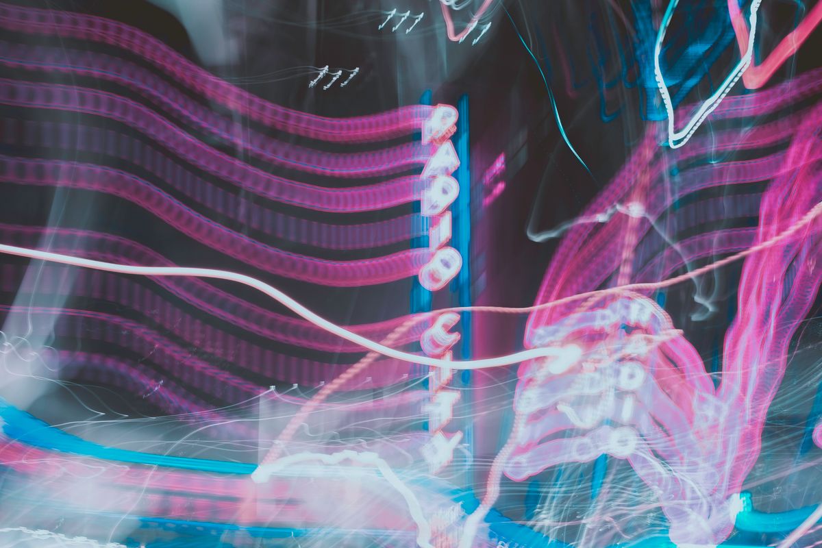 Abstract image of neon lights and signs at Radio City, showcasing vibrant colors and motion blur.