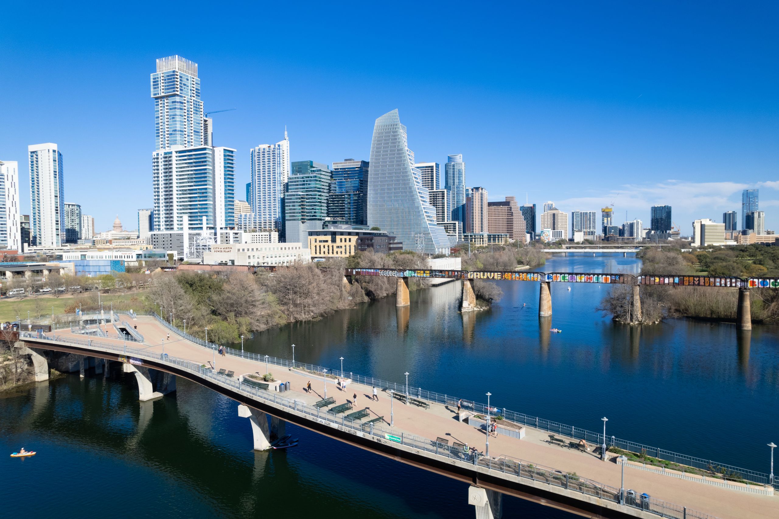 9 Cities Where Rent Could Devour Your First Paycheck Right Out of College 1 Aerial view of the modern Austin skyline featuring bridges over the river and towering skyscrapers.
