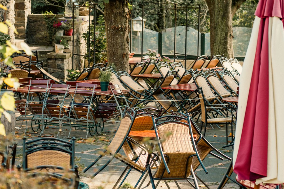 America’s Most Iconic Restaurants Are Disappearing Fast, and the Numbers Show Why 2026 Could Be the Breaking Point 2 An empty outdoor cafe with stacked chairs and tables in a serene fall setting, indicating closure or off-season.