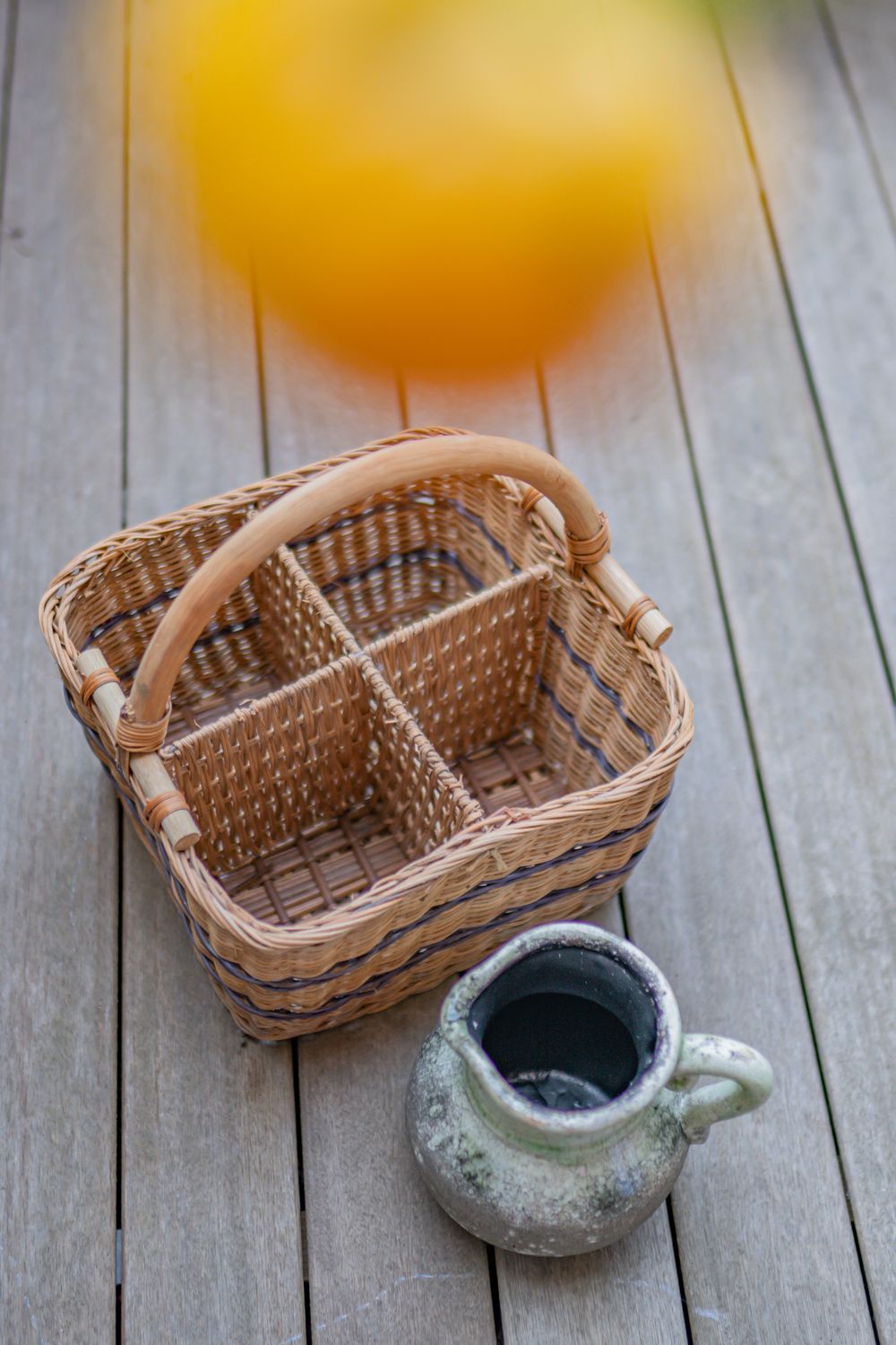 An overhead view of a woven basket and ceramic jug on a wooden table, creating a rustic and cozy atmosphere.