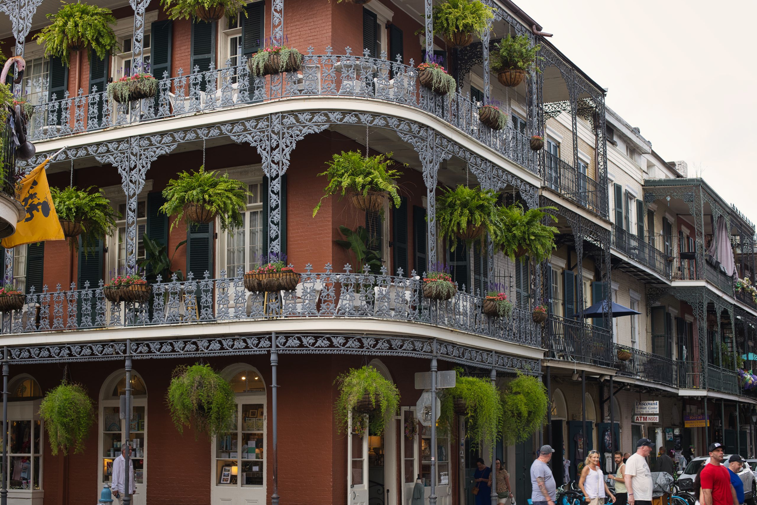 Beautiful wrought iron balconies and lush greenery in New Orleans' French Quarter.