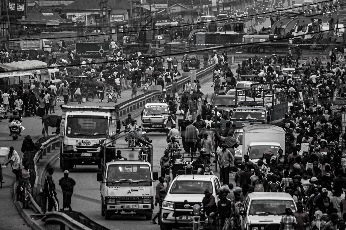 America Is Losing More Than Time in Traffic, and the New INRIX Scorecard Shows How Bad It Has Become 2 Black and white passenger cars and heavy vehicles surrounded by mob of pedestrians on asphalt road