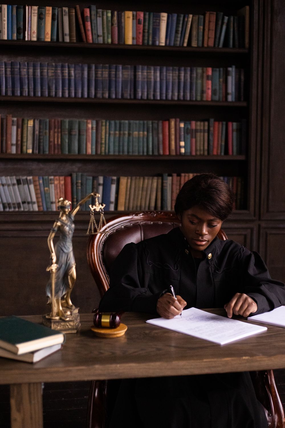 Maryland court records explained: how we search cases, property files, and public legal information in Maryland. 1 Black female judge sitting at desk in library, writing legal documents.