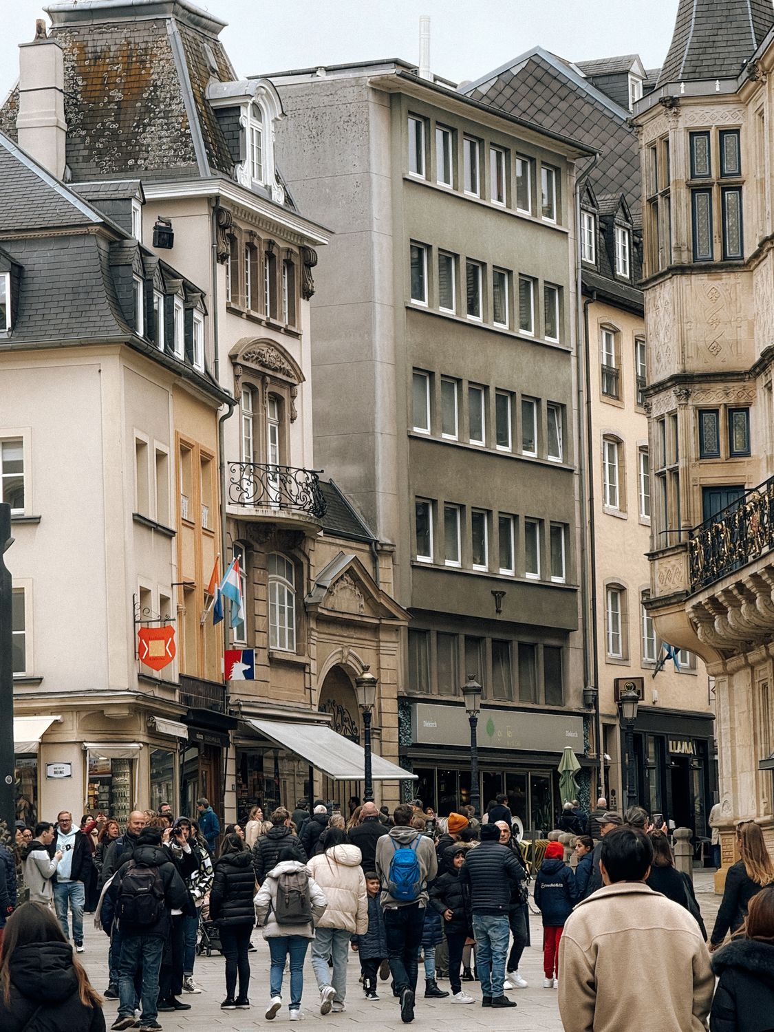 Busy urban street in Luxembourg City with people and classic European architecture.